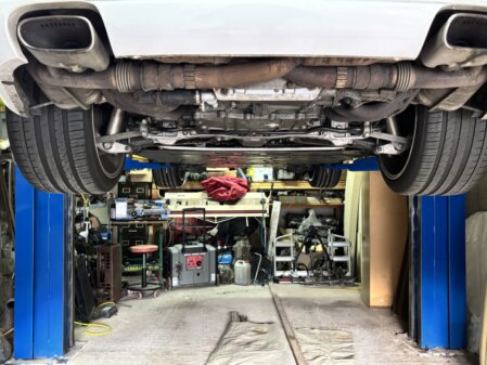 Kfz-Werkstattszene mit Fahrzeug auf Hebebühne